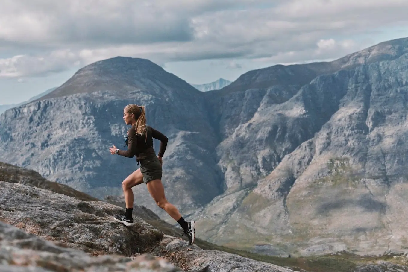 Trailrunnerin im Gebirge mit Garmin fēnix 9 Sportuhr